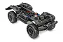 A high-angle studio shot of a Traxxas TRX-4 RC rock crawler chassis kit, showing the black frame, large off-road tires, and internal components.
