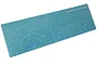A blue Tamiya cutting mat with white grid lines, measurements, and circular guides, shown from an angled perspective against a white background.