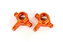 Two orange anodized aluminium front steering hubs for Traxxas RC vehicles, shown from a top-down perspective on a white background.