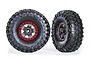 Two Traxxas 2.2 inch Canyon Trail crawler tires mounted on black wheels with red beadlock-style rings, shown from front and angled perspectives.
