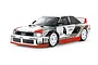 A studio shot of a Tamiya Audi 90 Quattro RC touring car model, featuring a white, red, and grey racing livery with number 4 decals.