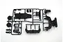 A black plastic parts tree for a Tamiya RC model containing various chassis components like shock towers and skid plates.