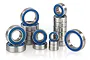A collection of various sized metal ball bearings with blue rubber seals arranged in stacks and groups against a white background.