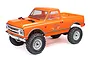 An orange Axial SCX24 1967 Chevrolet C10 RC rock crawler truck viewed from a front three-quarter angle against a white background.