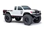 Side profile of a white Axial SCX24 Base Camp RC rock crawler truck with black wheels and off-road tires on a white background.