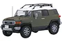 A 1/24 scale plastic model of an olive green and white Toyota FJ Cruiser SUV with a roof rack, shown from a front three-quarter angle.