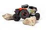 HPI Venture18 U4 Ford Bronco 4400 Flux RC rock crawler in grey and orange livery, climbing over two large rocks on a white background.