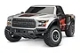 Traxxas Ford F-150 Raptor RC short course truck in silver and black with orange Fox Racing decals, shown from a front-quarter angle on a white background.