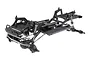 A studio shot of an unassembled Axial SCX10 Pro 1/10 scale RC rock crawler chassis kit, showing the black frame, suspension, and drivetrain components.
