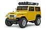 A studio shot of a yellow Tamiya CC-02 Toyota Land Cruiser 40 RC rock crawler kit with a white roof and black roof rack.