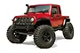 A red MST CFX-W JP1 RC rock crawler truck viewed from a front three-quarter angle against a white background.