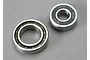 Two metal ball bearings of different sizes sitting on a grey surface.