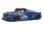 ARRMA Infraction 6S BLX RC street basher truck in blue camo livery, featuring black wheels with Hoons branding, shown from a side-angle on a white background.