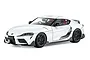 A studio shot of a white Tamiya 1/24 scale Toyota GR Supra model car with black wheels and carbon fiber style trim.
