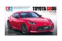 Tamiya 1/24 scale Toyota GR 86 plastic model kit box art showing a red sports car on a white background.