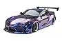 Studio shot of an MST RMX 2.5 A90RB RC drift car in iridescent purple finish, featuring a wide-body kit, rear wing, and black multi-spoke wheels.