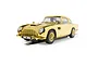 A 1/32 scale gold-plated Scalextric Aston Martin DB5 slot car with BMT 216A license plate on a white background.