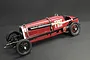 A 1/12 scale model of the red Fiat Mephistofele race car, featuring a long body, exposed engine details, and wire-spoke wheels on a dark background.