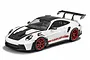 A high-detail 1/24 scale Tamiya model of a white Porsche 911 GT3 RS with red wheels and carbon fiber accents, shown from a front three-quarter angle.