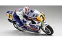 Kyosho 1/8 scale Honda NSR500 1991 RC motorcycle model with rider figure in racing leathers, shown leaning into a turn on a plain background.