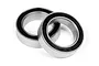 Two metal ball bearings with black rubber seals resting on a white background.