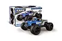 Maverick QBit 1/16 scale 4WD electric RC monster truck in blue and grey, shown in front of its product packaging box.