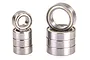 Two stacks of metal ball bearings of different sizes, showing a total of eight bearings arranged against a white background.