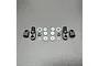 A set of RC shock rebuild components including two threaded shock caps, two rod ends, and various O-rings and spacers laid out on a grey surface.