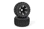 Two black RC monster truck wheels with aggressive tread patterns stacked on a white background.