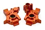Two orange anodized aluminium gearbox case halves for an RC car, shown from different angles on a white background.