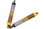 Two gold-coloured aluminium RC shock absorbers with black springs against a white background.