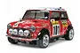 A Tamiya 1/10 scale RC Mini Cooper rally car, painted red with a white roof and numerous racing decals, shown against a plain white background.