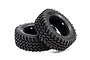 Two black Tamiya 1/10 scale mud block RC tyres shown from an angle against a white background.