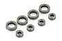 A set of eight metal shielded ball bearings of two different sizes arranged on a white background.