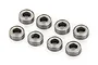 Eight small metal shielded ball bearings arranged in a group on a white background.