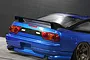 Rear view of a blue 1/10 scale RC Nissan 180SX drift car body featuring a black rear wing mounted on the trunk.