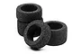 A set of four black foam RC car tyres arranged in a small stack and group on a white background.
