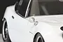 A close-up view of a silver classic-style fender mirror mounted on a white RC car body shell.