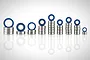 A collection of various sized metal ball bearings with blue rubber seals, arranged in stacks on a white reflective surface.