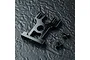 A black aluminium motor mount for an RC car, shown with four small black screws and two washers on a dark textured surface.
