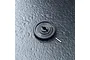 A black MST 50T spur gear with a small metal pin resting on a textured dark grey surface.
