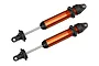 Two Traxxas orange anodized aluminium GTX shock absorbers for RC vehicles, shown against a white background.