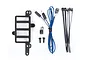 Traxxas Pro Scale lighting components including a black plastic mount, LED lights with wiring, zip ties, and small screws on a white background.