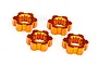 Four orange anodized aluminium wheel hexes for Traxxas RC vehicles arranged on a white background.