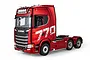 A red Huina Scania 770S RC semi truck model viewed from a three-quarter angle against a white background.