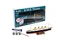 Revell 1/1200 scale R.M.S. Titanic plastic model starter kit, including the box, assembled ship model, glue, paints, and a paintbrush.