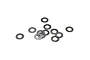 A collection of twelve small, thin, circular metal shims or washers scattered on a plain white background.