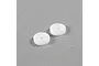Two white circular shock pistons with two small holes each, sitting on a grey surface.