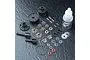 A complete MST V2 bevel differential kit laid out on a dark textured surface, including plastic housing parts, metal gears, pins, screws, and gear oil.