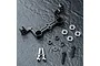 MST black aluminium steering joint plate with included bearings, screws, and spacers on a dark textured surface.